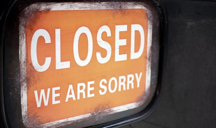 an orange sign saying closed we are sorry 