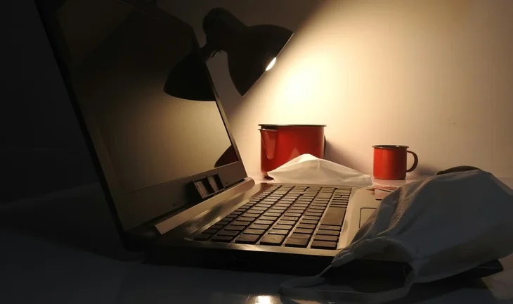 a laptop with some cups in the night 