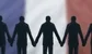 French bankers holding hands in front of flag