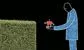 a man offering a small robot to a hedge